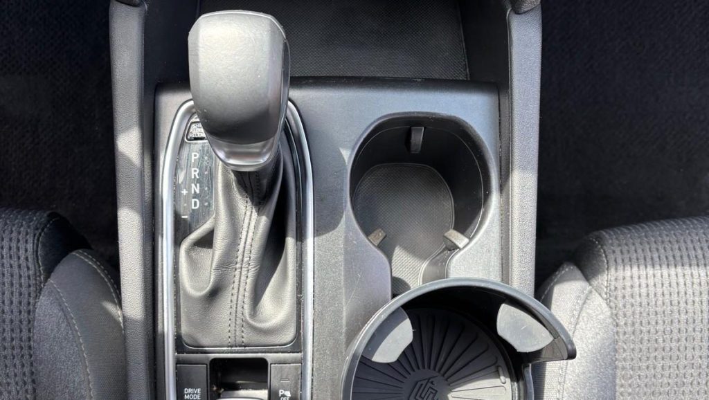 Top-view looking down on a car's centre console, showing clean cupholders and areas around the gear selector