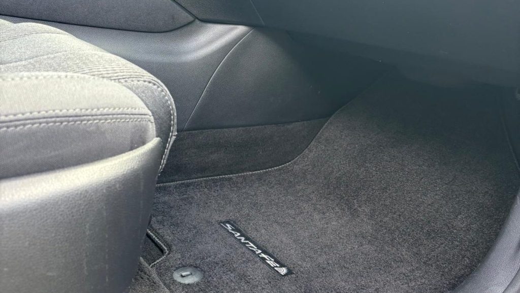 View from the passenger door looking into a car with vacuumed and carpet cleaned carpets and seats, as well as a dusted and wiped down dashboard